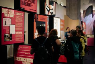 Des personnes regardent des modules d’exposition dans un espace public.