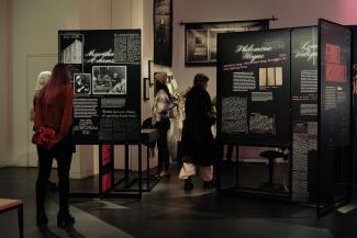 Des personnes regardent des modules d’exposition dans un espace public.