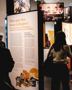 Des personnes regardent des modules d’exposition dans un espace public.