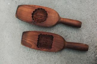 Two wooden mooncake molds. Carved into their hollows are motifs and the name of the pastry shop in Chinese characters.