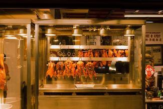 Close-up of roasted poultry hanging in a barbecue case.