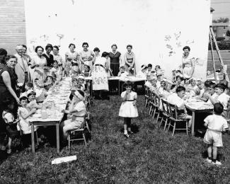 Une cinquantaine d’élèves accompagnés de parents font un pique-nique à l’extérieur.