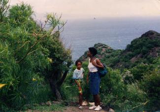 Une mère et sa jeune fille en Guadeloupe, avec la mer en arrière-plan