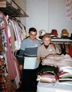 Photo couleur d’un couple de personnes âgées se tenant debout dans un magasin de vêtements.