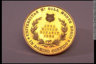 Médaille ronde et dorée sur laquelle on peut voir un blason et une couronne de laurier. Au centre, le nom d’Anne Molson et l’année 1864 sont visibles.