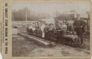 Henri-Ucal, sept ans, le fils aîné des Dandurand, se tient devant le plus petit train à vapeur du monde.