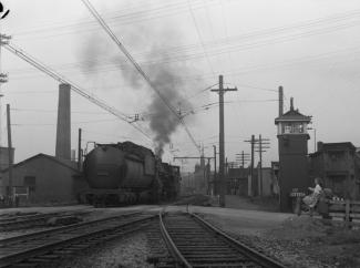 La locomotive et le wagon de queue passent sur la voie ferrée devant Gabrielle Roy.