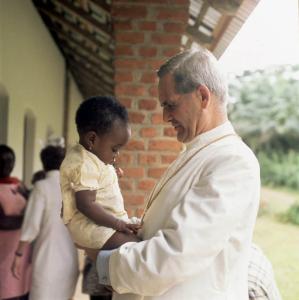 Photographie du cardinal Léger tenant une enfant.dans un centre.