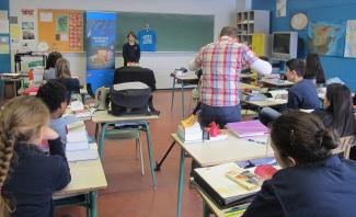 Un caméraman filme la présentation orale d’un élève du niveau secondaire sur son trésor de famille dans une classe.