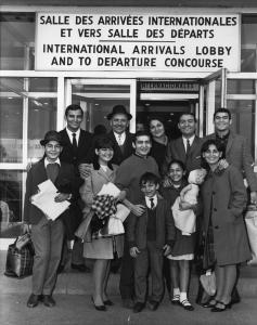 Onze personnes souriants, debouts à l'aéroport à la salle des arrivées internationales.