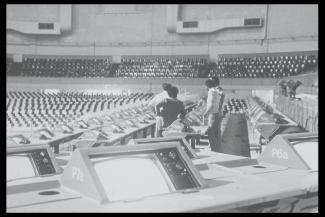 Photographie des équipements de télécommunication du stade, avec les techniciens au centre.