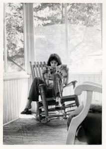 Pierre Huet lit un magazine Spirou assis sur une véranda