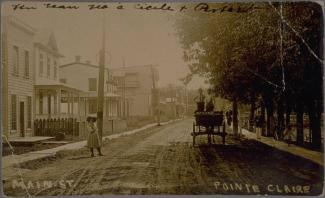 Rue de Pointe-Claire au début du XXe siècle avec une des maisons à gauche, la rue au centre et des arbres à droite.