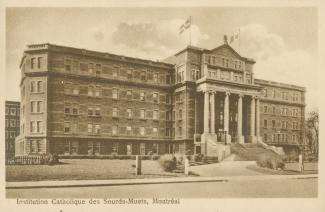 Vaste bâtiment de pierres, de cinq étages, avec une imposante entrée comprenant un grand escalier et des colonnes. 