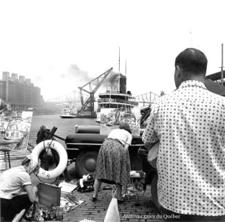 Photo de peintres installés le long d’un quai du port de Montréal.