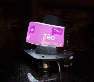 Photo couleur en gros plan d’un lanternon rose de Téo taxi. 