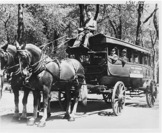 Vue d'un Omnibus tiré par deux chevaux avec à son bord des employés de la compagnie.