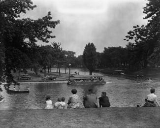 Photographie de promeneurs dans le parc La Fontaine.. L'étang est situé au centre.