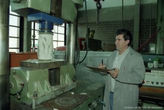 Un homme observe une machine dans un atelier.