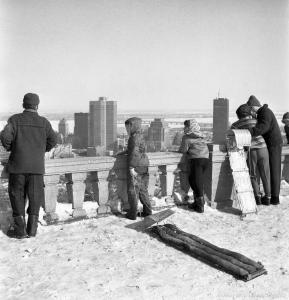 Scène d'hiver sur le belvédère du mont Royal. Des enfants et des adultes admirent la vue sur le centre-ville.