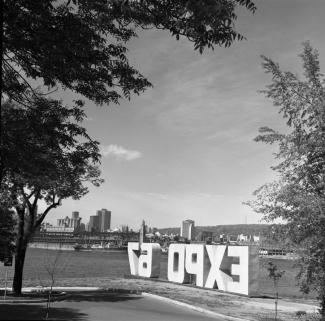 Les lettres « Expo 67 » sont installées, suite aux cérémonies du début des travaux, sur l’île Sainte-Hélène, près du fort.