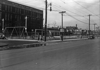 Photo noir et blanc montrant le parc Sainte-Cunégonde en avant-plan et les bureaux de la Stelco à l’arrière-plan.