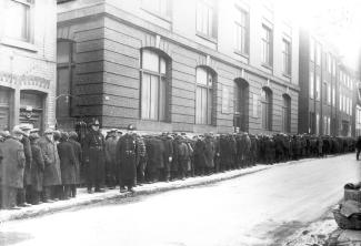 Photographie d'une file d'attente de chômeurs devant l'entrée du refuge Meurling (435, rue du Champ-de-Mars) lors de la crise économique des années 1930. 