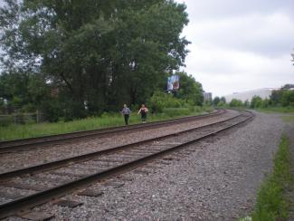 Photo contemporaine d’une voie ferrée double avec un homme et une femme marchant à côté.