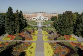 Photographie couleur de la façade de l'édifice Marie-Victorin et des jardins d'accueil à l'avant.