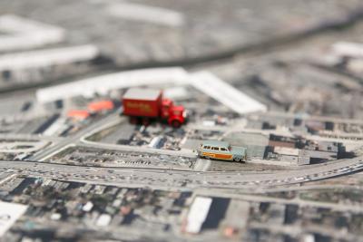 Une maquette montre une route et des petites voitures dans un environnement urbain.