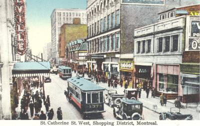 Carte postale de la rue Sainte-Catherine avec un tramway et des voitures qui circulent dans la rue.