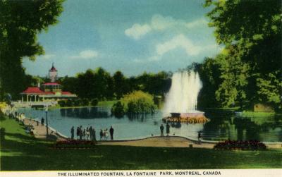 Carte postale montrant le restaurant, l'étang et la fontaine illuminée du parc La Fontaine. 