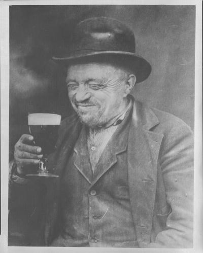 Vieil homme buvant une bière.