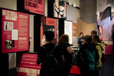 Des personnes regardent des modules d’exposition dans un espace public.
