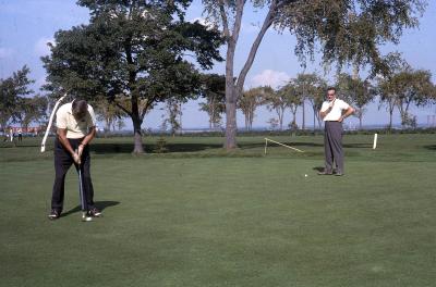 Photographie couleur de deux hommes jouant au golf.