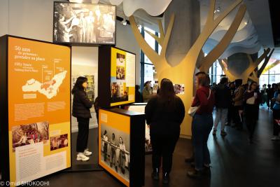 Des personnes regardent des modules d’exposition dans un espace public.