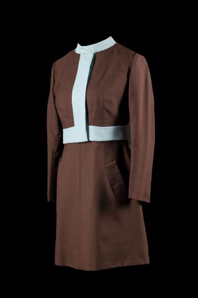 Robe et veste constituant l’uniforme d’une hôtesse du Québec ayant appartenu à Monique Michaud. Costume brun aux accents bleu pâle dessiné par Serge & Réal.