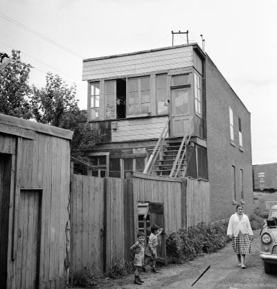 Une femme et deux enfants sur le côté d’une maison rue Britannia.