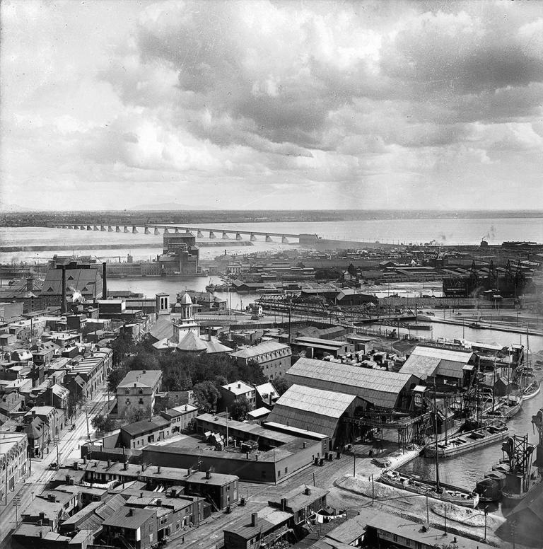 Vue aérienne de Griffintown à la fin du XIXe siècle avec l’église Sainte-Anne, le canal de Lachine et le pont Victoria en arrière-plan