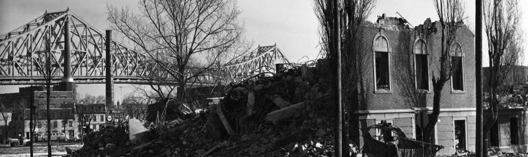 Bâtiment démoli dans le quadrilatère de Radio-Canada, avec le pont Jacques-Cartier en arrière-plan, 1963.