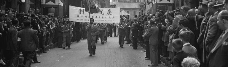 Foule qui célèbre dans le Quartier chinois. On peut lire sur une banderole "V-J Day celebration by the Chinese community of Montreal".