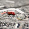 Une maquette montre une route et des petites voitures dans un environnement urbain.