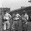 Photo en noir et blanc de quatre joueurs de baseball de l’équipe des Royals. Chacun s’appuie sur un bâton de baseball.