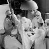 Photo en noir et blanc d’un médecin et ses assistants dans une salle d’opération