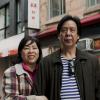Colour photo of a woman and a man standing next to each other in front of a building in Montréal’s Chinatown.