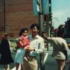 Photo couleur d’un homme tenant une petite fille dans ses bras sur le trottoir le long de la rue Saint-Urbain. 
