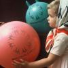 Petite fille avec foulard Expo 67 et deux ballons avec le logo d’Expo 67