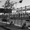 Des échafaudages métalliques et des banderoles annonçant « Corridart dans la rue Sherbrooke » placés sur le trottoir. Derrière, des automobiles circulent. En arrière-plan, le stade olympique de Montréal.