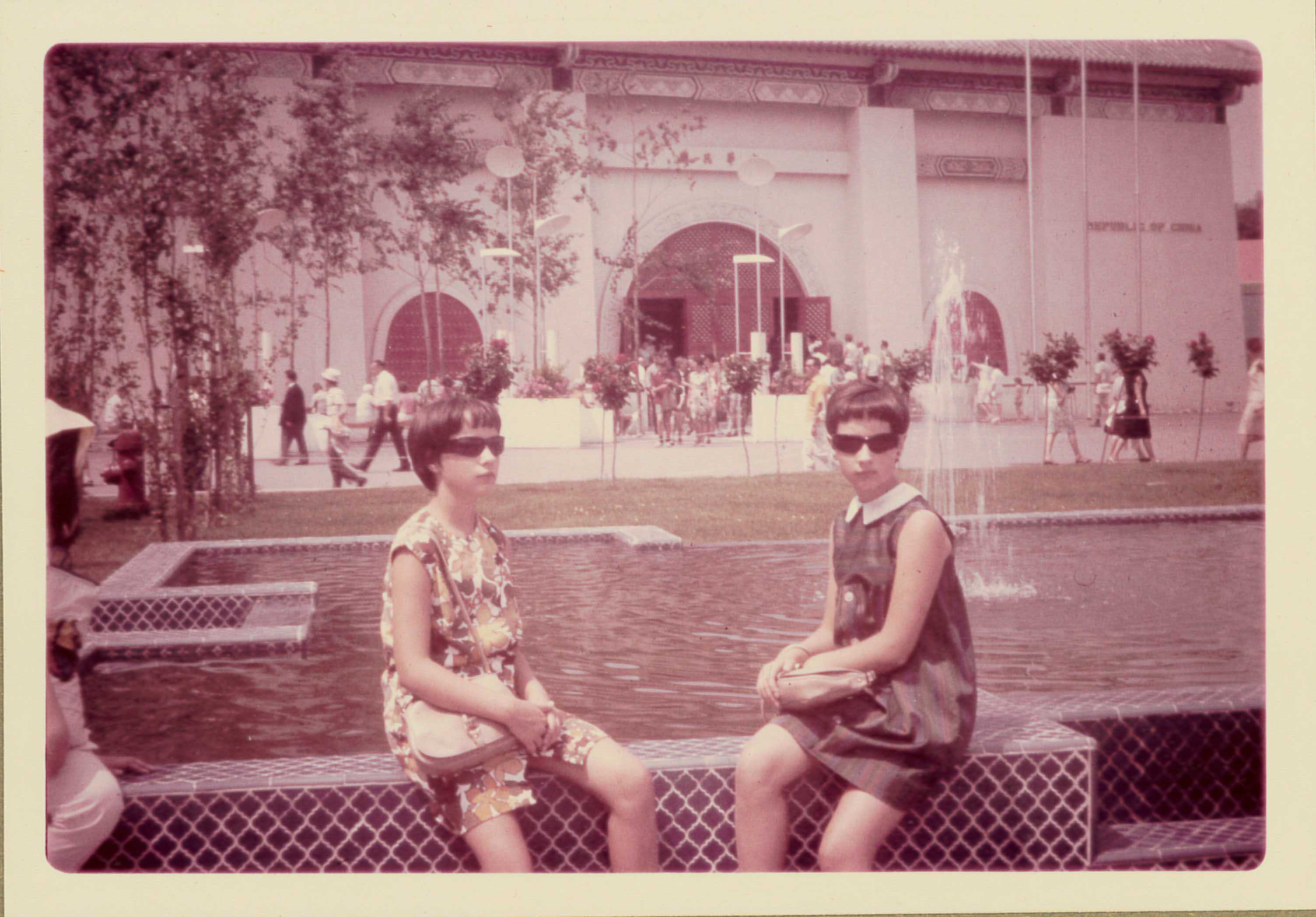 Yolande et sa sœur prennent la pose assises sur le bord d’une fontaine