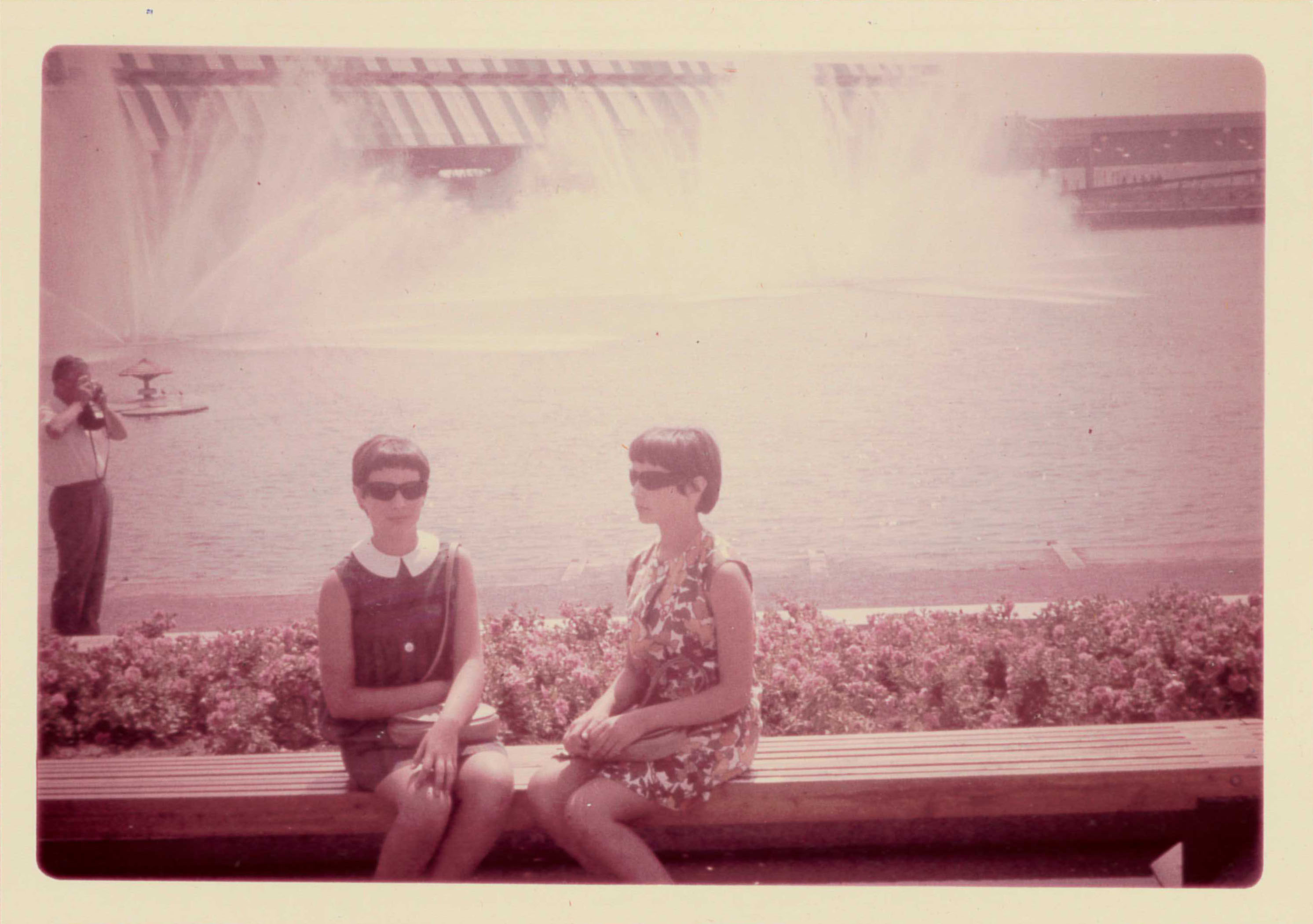 Yolande et sa sœur prennent la pose assises sur le bord d’une fontaine